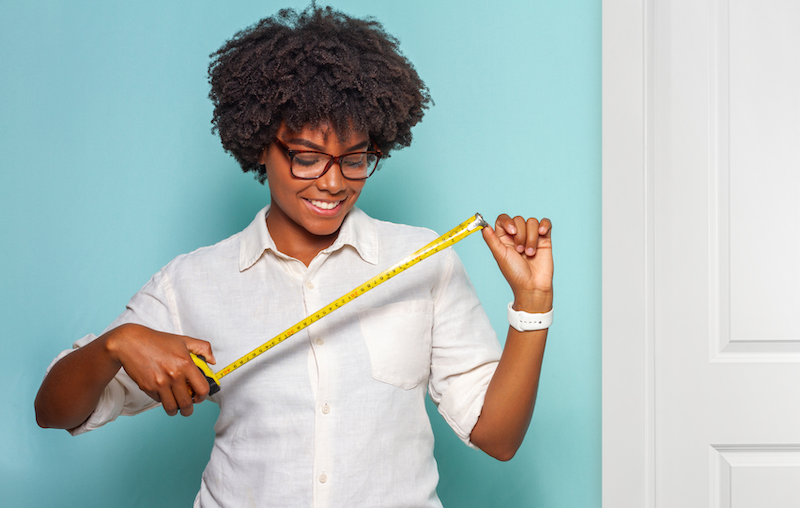 Woman measuring closet with tape measure